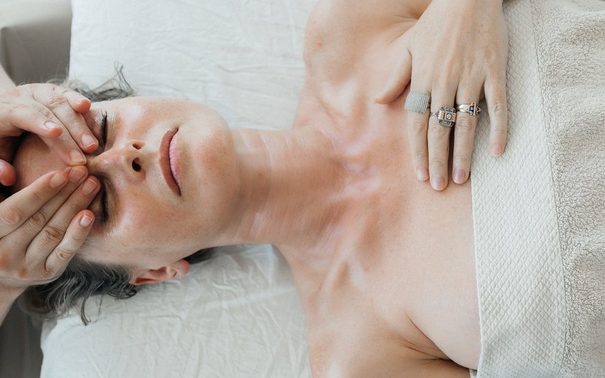The hands of the therapist on a client's face